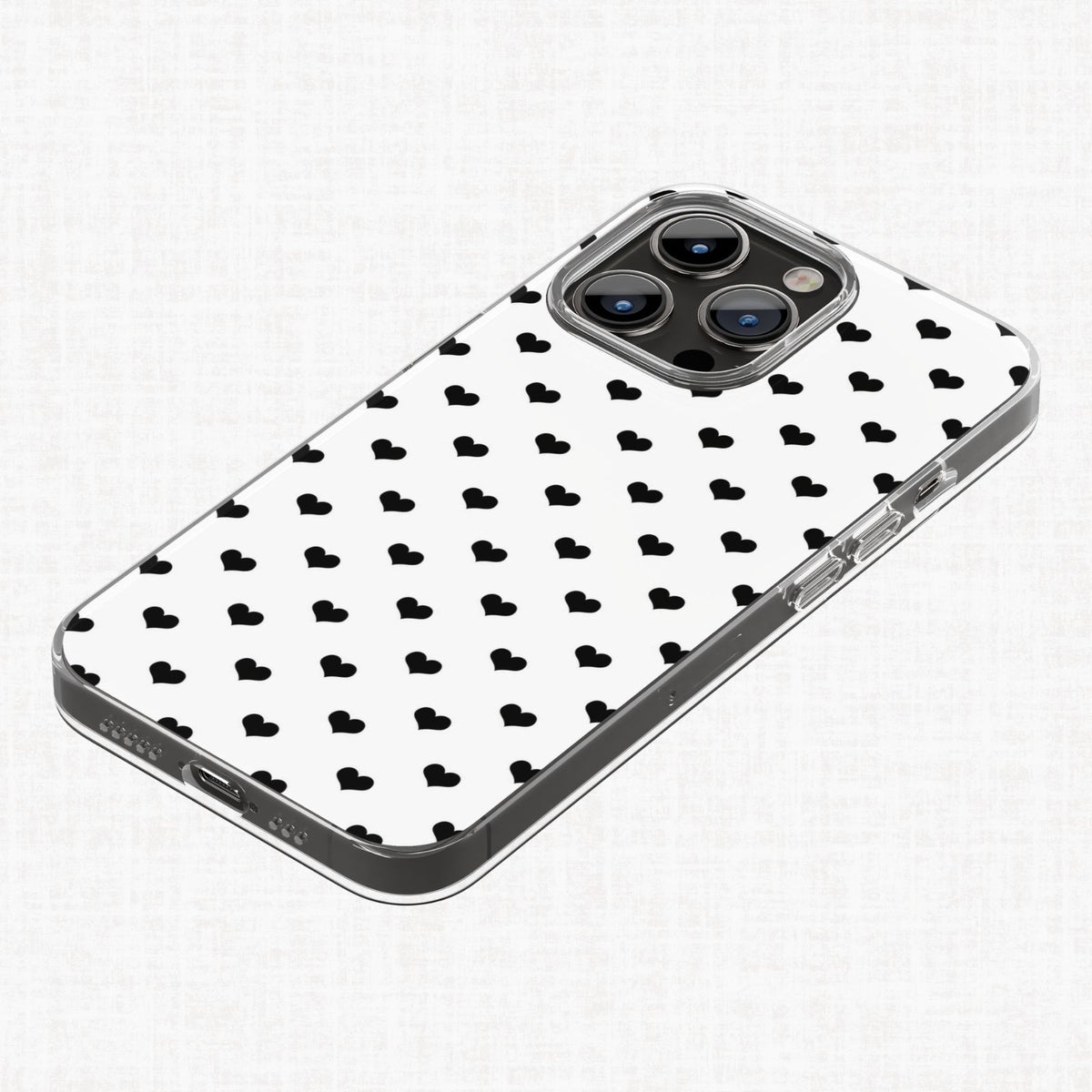 Clear phone case mockup shown with a small black heart repeating pattern on a white background from the Essential Geo digital paper collection.