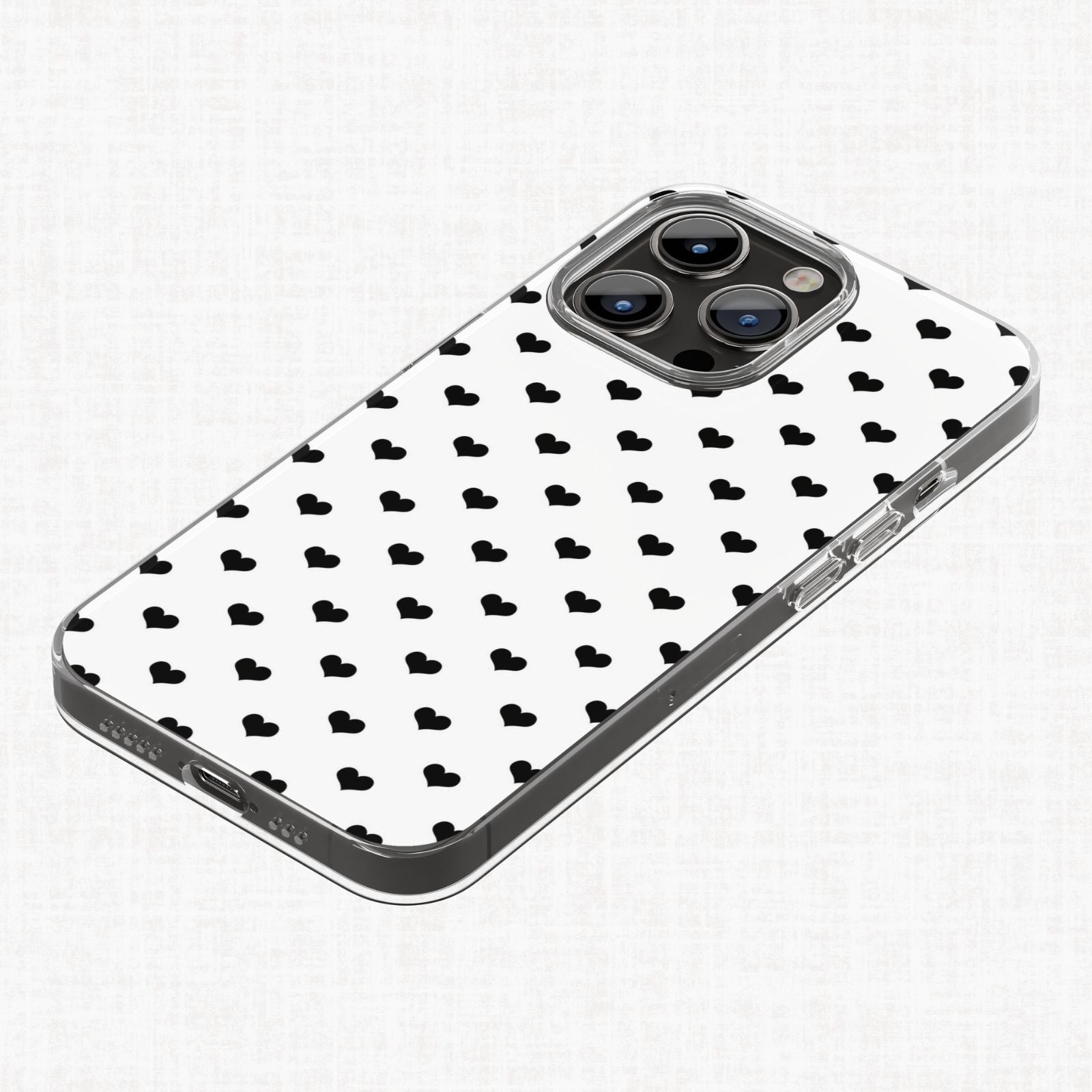 Clear phone case mockup shown with a small black heart repeating pattern on a white background from the Essential Geo digital paper collection.
